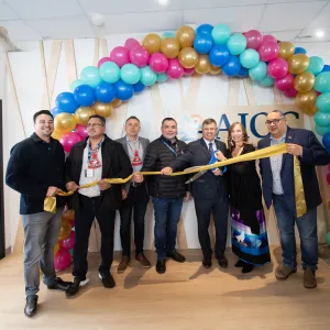 Group cutting the ribbon at the AIOC enoch office opening