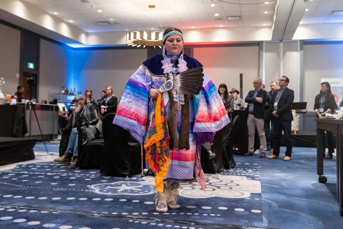 Lady in traditional ceremonial clothing performing a dance