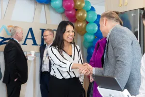 Lady smiling shaking a mans hand