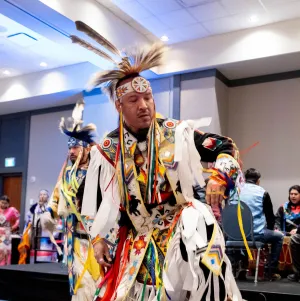 Man performing a ceremonial dance at the AIOC Enoch office opening