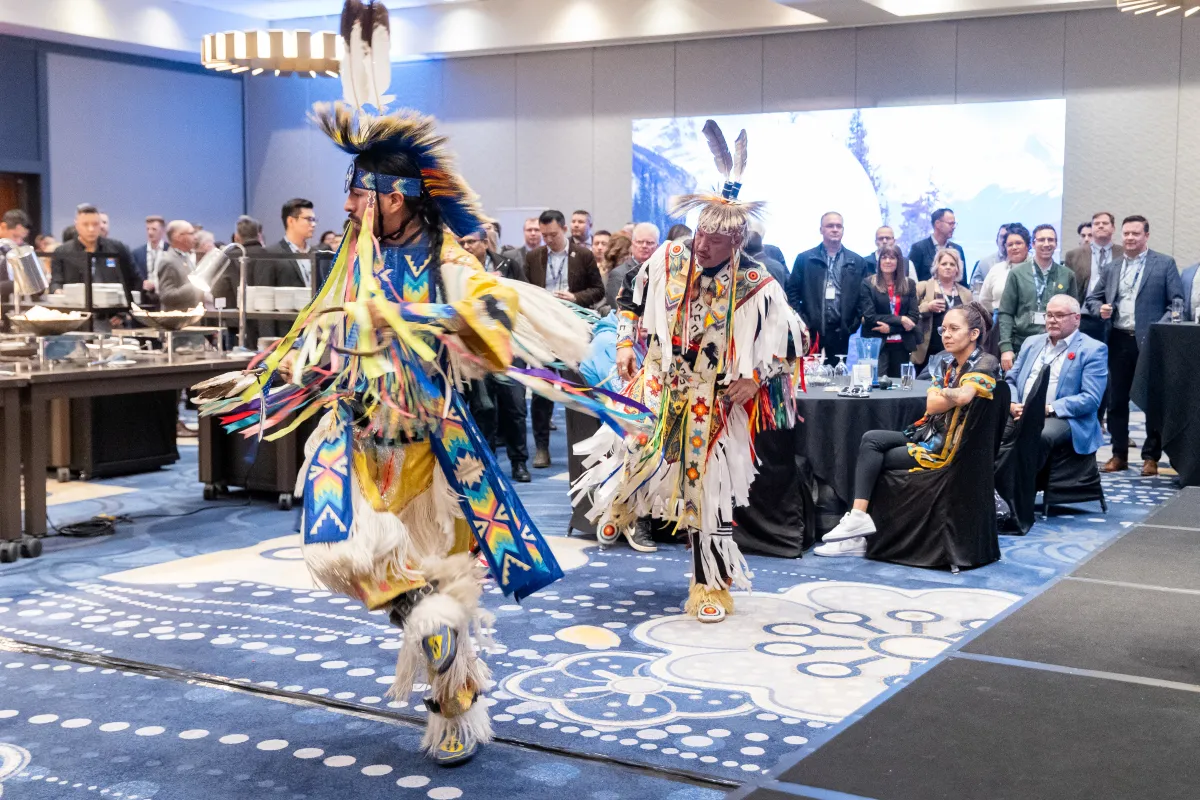 Two dancers in traditional attire doing ceremonial dance at aioc enoch office opening