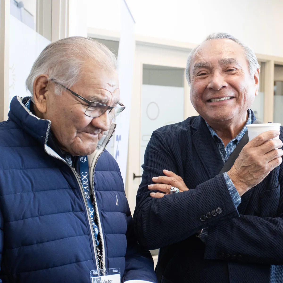 Two elderly gentlemen chatting at the AIOC enoch office opening
