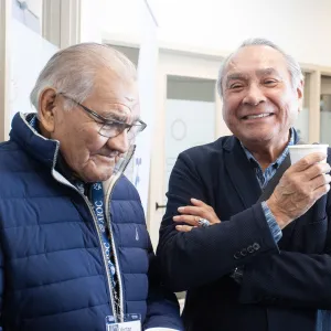 Two elderly gentlemen chatting at the AIOC enoch office opening